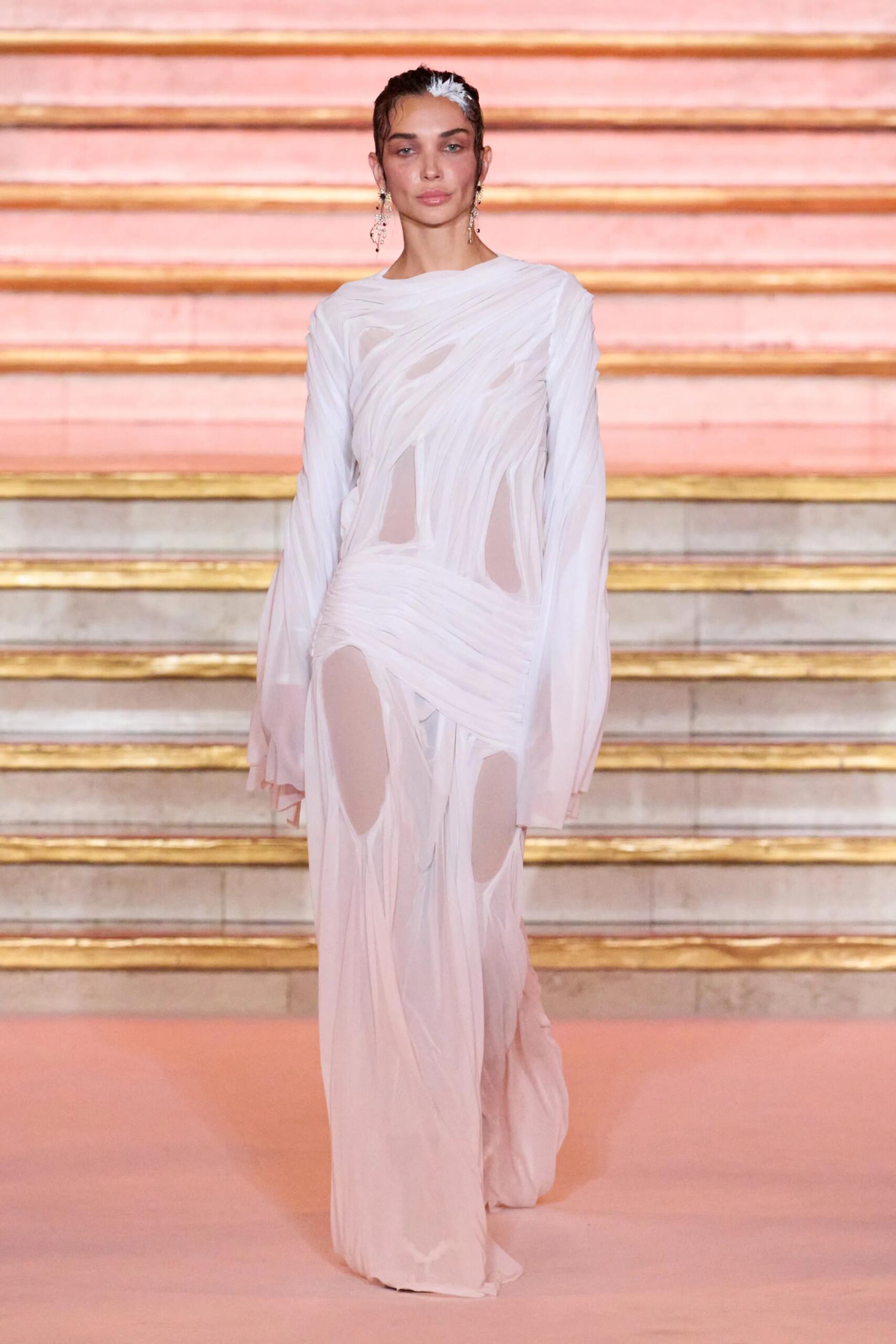 Di Petsa printemps-été 2027, look 1 : Robe blanche wet-look, drapée et transparente.